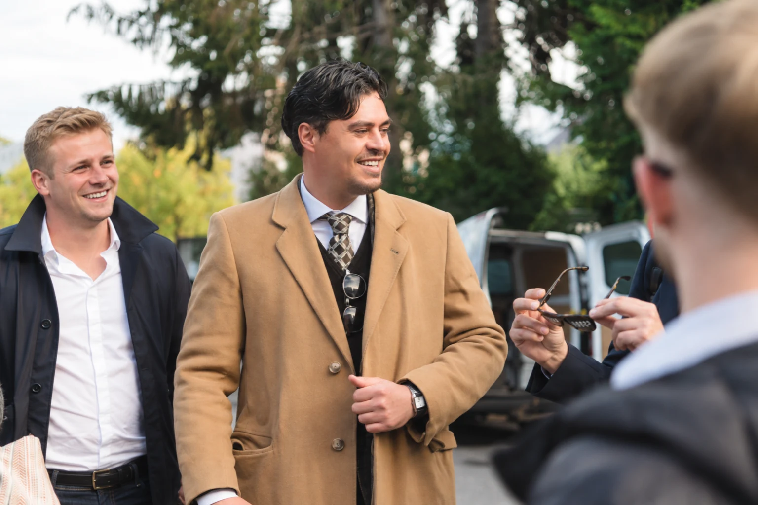 Michael, en manteau beige, échange avec des professionnels de l’immobilier.